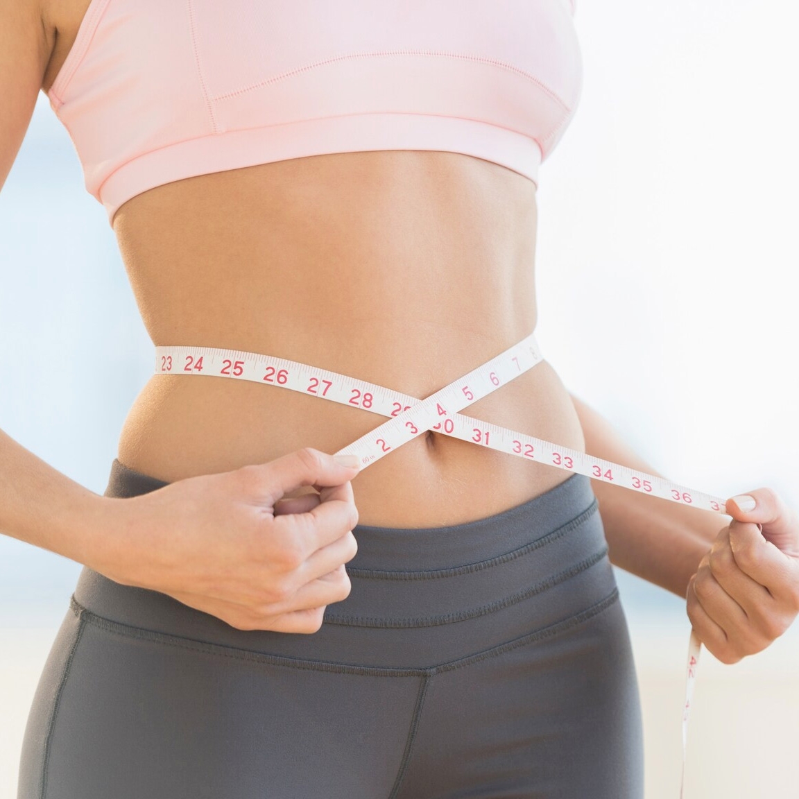 woman with ruler around waist